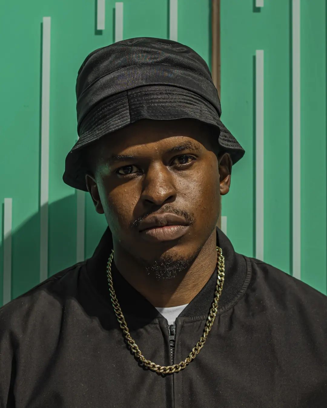 Portrait of Kamo. G wearing a black bucket hat and jacket